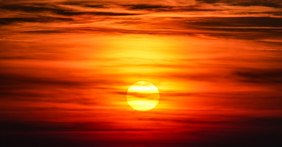 Captivating sunset with vibrant orange hues filling the sky and dramatic cloud formations.
